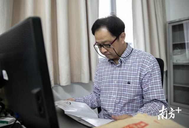 加藤隆则在办公室看书。 加藤隆则在办公室看书。