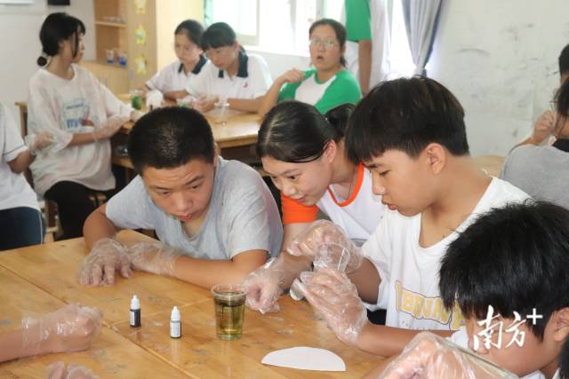 汕头大学理学院志愿者们和同学观察“彩虹雨”的现象。
