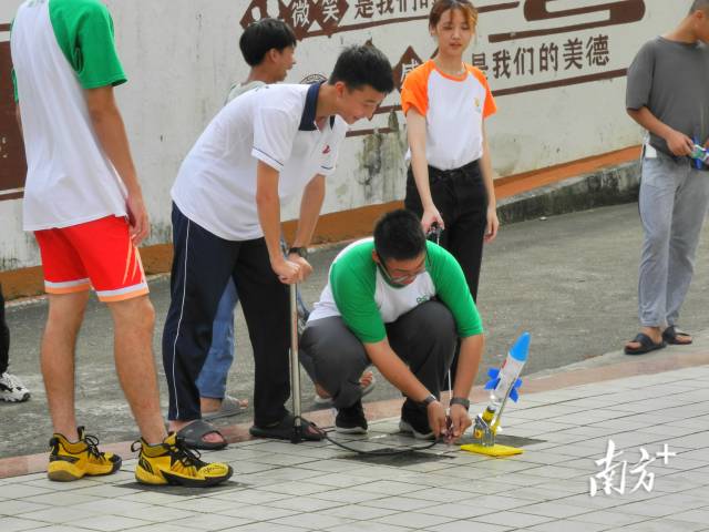 汕头大学理学院志愿者们和同学们一起将自己设计制作的水火箭架设发射。